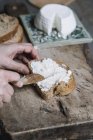 Жінка розкладає рикотський сир на шматочок хліба, крупним планом — стокове фото