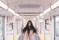 Portrait of young woman on subway train — Stock Photo