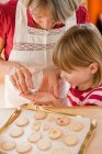 Grandma and grandchild baking biscuits — Stock Photo