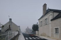 Sentiero dei fari posteriori su strada attraverso il villaggio Meigne-le-Vicomte la mattina nebbiosa, Valle della Loira, Francia — Foto stock