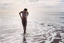 Jovem mulher andando na costa do mar — Fotografia de Stock