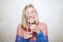 Портрет жінки, що п'є смузі, посміхається — стокове фото