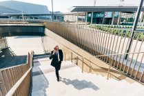 Reifer Geschäftsmann läuft mit Smartphone Treppe hoch — Stockfoto