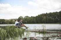 Casal maduro relaxante no cais de madeira perto do lago — Fotografia de Stock