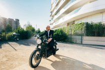Портрет зрілого бізнесмена, що сидить на мотоциклі — стокове фото