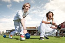 Deux jeunes hommes pelouse bowling sur bowling vert — Photo de stock