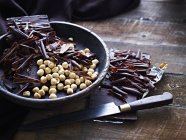 Chocolate shavings and hazelnuts in bowl — Stock Photo