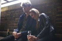 Romantisches junges Paar sitzt in Wartehalle mit Prosecco — Stockfoto