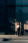 Woman standing in shadows by building, Milan, Italy — Stock Photo