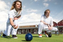 Two young men lawn bowling on bowling green — Stock Photo