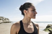 Портрет молодой бегуньи, смотрящей с пляжа — стоковое фото