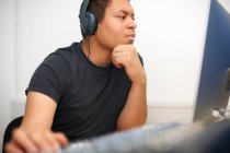 Young male college student at mixing desk in TV studio — Stock Photo