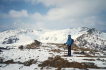 Senderista en montaña nevada, Coniston, Cumbria, Reino Unido - foto de stock