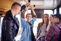 Cinque giovani amici adulti in chat sul tram della città — Foto stock