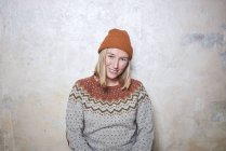 Portrait of woman wearing jumper and knitted hat, smiling — Stock Photo