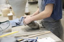 Cropped view of woman in art studio kneading clay — Stock Photo