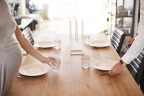 Cropped shot of pregnant couple laying dining table — Stock Photo