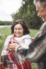 Mature couple holding hot drinks in rural setting — Stock Photo