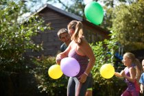 Família brincando com balões no jardim — Fotografia de Stock