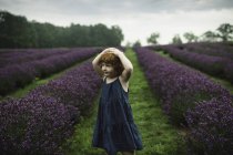 Toddler girl standing between rows of lavender — Stock Photo