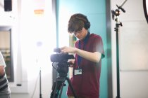 Young male college student filming in TV studio — Stock Photo