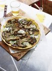 Porcini pizza on baking paper and serving board — Stock Photo