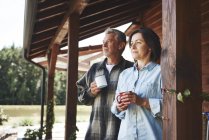 Älteres Paar steht mit Blechbechern auf der Terrasse — Stockfoto