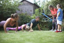 Семейные упражнения и отжимания в саду — стоковое фото