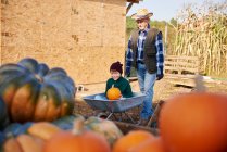Farmer and grandson at pumpkin farm — Stock Photo