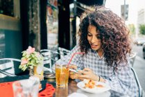 Mulher usando telefone celular no café do pavimento, Milão, Itália — Fotografia de Stock