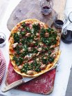 In Scheiben geschnittene italienische Wurst-Pizza auf Servierbrett, Draufsicht — Stockfoto