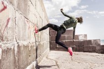 Seitenansicht eines jungen Mannes, der gegen eine Wand läuft — Stockfoto