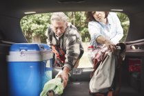 Couple d'âge mûr enlever l'équipement de camping du coffre de voiture — Photo de stock