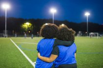 Female football players sitting by field, Hackney, East London, UK — Stock Photo