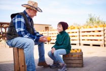 Farmer and grandson at pumpkin farm — Stock Photo