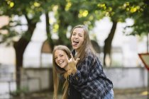 Портрет молодої жінки даючи друг Хрюшка назад в парку — стокове фото