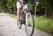 Hombre mayor ciclismo a lo largo de la ruta - foto de stock
