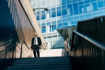 Mature businessman walking down on steps outdoors — Stock Photo