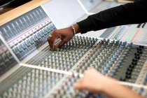 Mains d'étudiants masculins au mixeur dans un studio d'enregistrement — Photo de stock