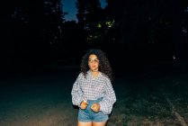 Portrait of young woman in park at night — Stock Photo