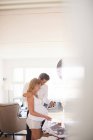 Pregnant couple looking at ultrasound pictures in living room — Stock Photo
