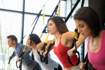 Freunde trainieren mit Widerstandsband im Fitnessstudio — Stockfoto