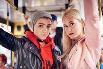 Two young women standing on city tram — Stock Photo