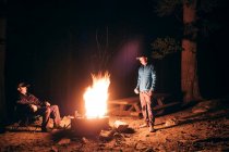 Friends camping in forest by campfire, Mammoth Lake, California, USA, North America — Stock Photo