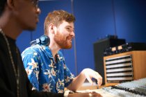 Two young male college students at sound mixer in recording studio — Stock Photo