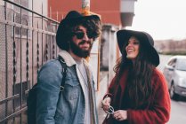Junges Paar steht an Bushaltestelle und lacht — Stockfoto