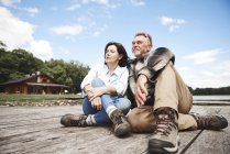 Mature couple relaxing on wooden pier — Stock Photo