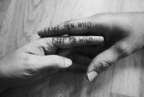 Couple, hands touching, writing on index fingers, close-up — Stock Photo