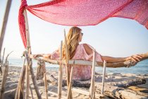 Vista trasera de la mujer relajándose en la playa, Palma de Mallorca, Islas Baleares, España, Europa - foto de stock