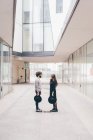 Young man and woman standing face to face in urban environment — Stock Photo
